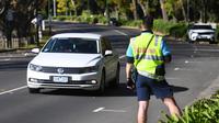 Polisi memantau lalu lintas saat lockdown akibat virus corona di Melbourne akan diperpanjang, Rabu (2/6/2021). Kota Melbourne dan wilayah lainnya di negara bagian Victoria, Australia, akan mengalami perpanjangan lockdown yang tadinya dijadwalkan berakhir pada Kamis (3/6) malam. (William WEST / AFP)