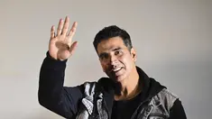 Aktor Bollywood Akshay Kumar menyapa penggemar selama acara promosi filmnya 'Raksha Bandhan' di Kolkata (8/8/2022). Akshay tampil necis dalam setelan olahraga hitam dan jaket denim. (AFP/Dibyangshu Sarkar)