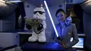 Seorang Pramugari menyapa pengunjung sambil memegang lightsabre atau pedang laser di pesawat Boeing 787 Dreamliner, Singapura, Kamis (12/11/2015).  Pesawat bertema Star Wars ini menjadi pertama di Asia Tenggara. (REUTERS/Edgar Su)