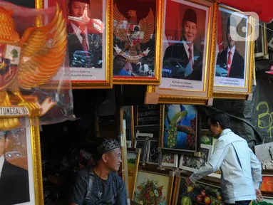 Pedagang bingkai foto bergambar presiden dan wakil presiden terpilih 2024-2029 menunggu pembeli di Pasar Baru Jakarta, Senin (22/4/2024). (merdeka.com/Imam Buhori)
