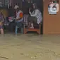 Warga berada di salah satu warung yang terendam banjir di Desa Sukalaksana Kabupaten Bekasi, Jawa Barat, Senin (22/02/2021). Jebolnya tanggul Sungai Citarum ini disebabkan oleh debit air yang tinggi. (Liputan6.com/Herman Zakharia)