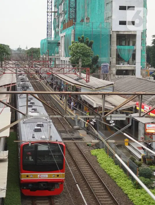 Kereta commuterline melintas dekat proyek pembangunan Apartemen Mahata Tanjung Barat di sekitar Stasiun Tanjung Barat, Jakarta, Kamis (30/1/2020). Proyek ini menempel Stasiun Tanjung Barat dan dekat dengan pusat perkantoran, pusat perbelanjaan, dan tempat rekreasi. (Liputan6.com/Immanuel Antonius)
