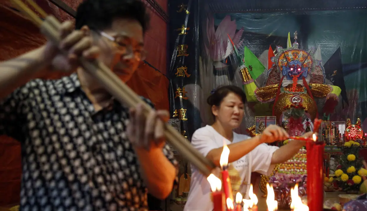 Beberapa orang menyalakan dupa saat festival Hungry Ghost di Kuala Lumpur, Malaysia, (3/8/2014). (REUTERS/Olivia Harris)