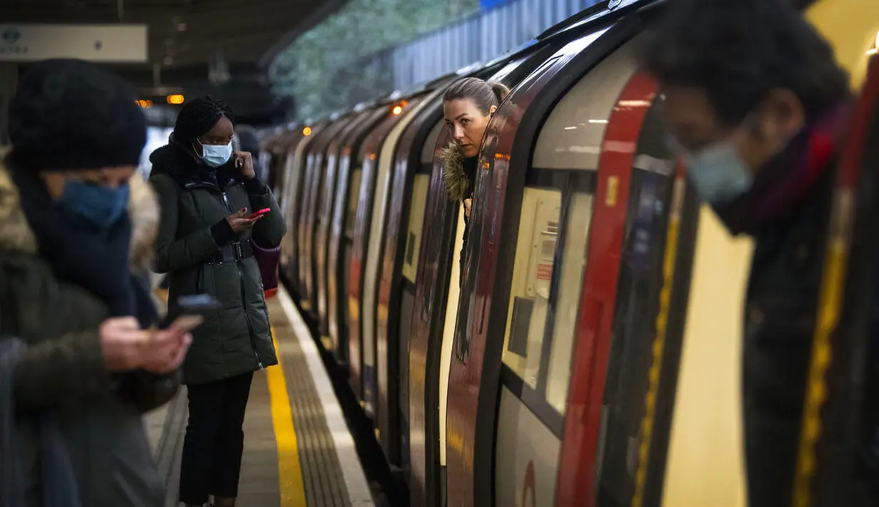 Para penumpang naik kereta Bawah Tanah Jubilee Line di Stasiun Canning Town selama jam sibuk di London, Inggris, 12 Januari 2021. Inggris sedang menerapkan lockdown nasional ketiga untuk mengekang penyebaran virus corona COVID-19. (Victoria Jones/PA via AP)