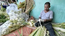Pedagang membuat kulit ketupat untuk dijual di Pasar Minggu, Jakarta Selatan, Senin (4/7). H-2 Hari Raya Idul Fitri, pedagang kulit ketupat mulai kebanjiran pembeli. (Liputan6.com/Yoppy Renato)
