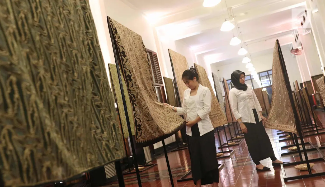 Sejumlah pengunjung melihat kain batik di Musium Bank Mandiri, Jakarta, Rabu (25/10). Pameran batik 100 kain negeri tersebut merupakan karya desainer Oscar Lawalata. (Liputan6.com/Angga Yuniar)