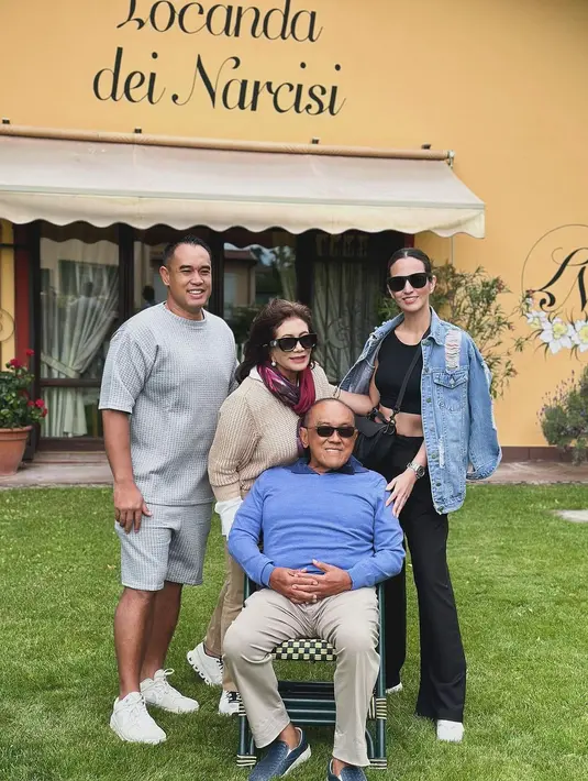 Nia Ramadhani tampil kasual saat foto bersama mertua. Ia kenakan croptop dan celana hitam dengan ripped denim jacket. [@ramadhaniabakrie]