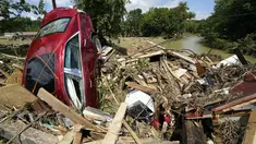 Sebuah mobil termasuk di antara puing-puing yang terdampar di jembatan di atas sungai di Waverly, Tennessee, Minggu (22/8/2021). Banjir parah yang melanda Middle Tennessee, AS, menyebabkan sedikitnya 22 orang tewas, sementara sekitar 50 orang lainnya dilaporkan masih hilang. (AP Photo/Mark Humphrey
