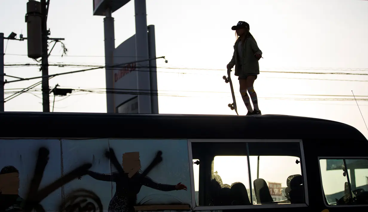 Sky Brown berada di atas sebuah bus saat bermain skateboard di kota Takanabe, prefektur Miyazaki, Jepang (14/1). Sky sudah berlatih skateboard secara serius sejak umur 3 tahun. (AFP/Behrouz Mehri)