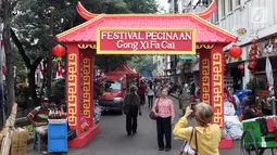 Pengunjung berfoto di depan pintu masuk area Festival Pecinan 2019 di kawasan jalan Pancoran, Glodok, Jakarta, Rabu (20/2). Festival Pecinan 2019 digelar untuk memeriahkan perayaan Imlek dan Cap Go Meh. (Liputan6.com/Helmi Fithriansyah)