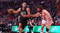Pemain Nets, Brook Lopez (11) berusaha melewati hadangan saudara kembarnya pemain Chicago Bulls, Robin Lopez (8) pada lanjutan NBA basketball game, (28/12/2016) di United Center.  Bulls menang 101-99. (Reuters/Mike DiNovo-USA TODAY Sports)