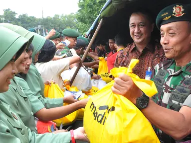 Pangkostrad Letjend TNI Mulyono (kanan) melayani pembeli dalam bazar murah menyambut Idul Fitri 1436 H, di Lapangan Kostrad, Jakarta, Selasa (7/7/2015). Bazar ini dikhususkan bagi para prajurit dan PNS di lingkungan Kostrad. (Liputan6.com/Herman Zakharia)