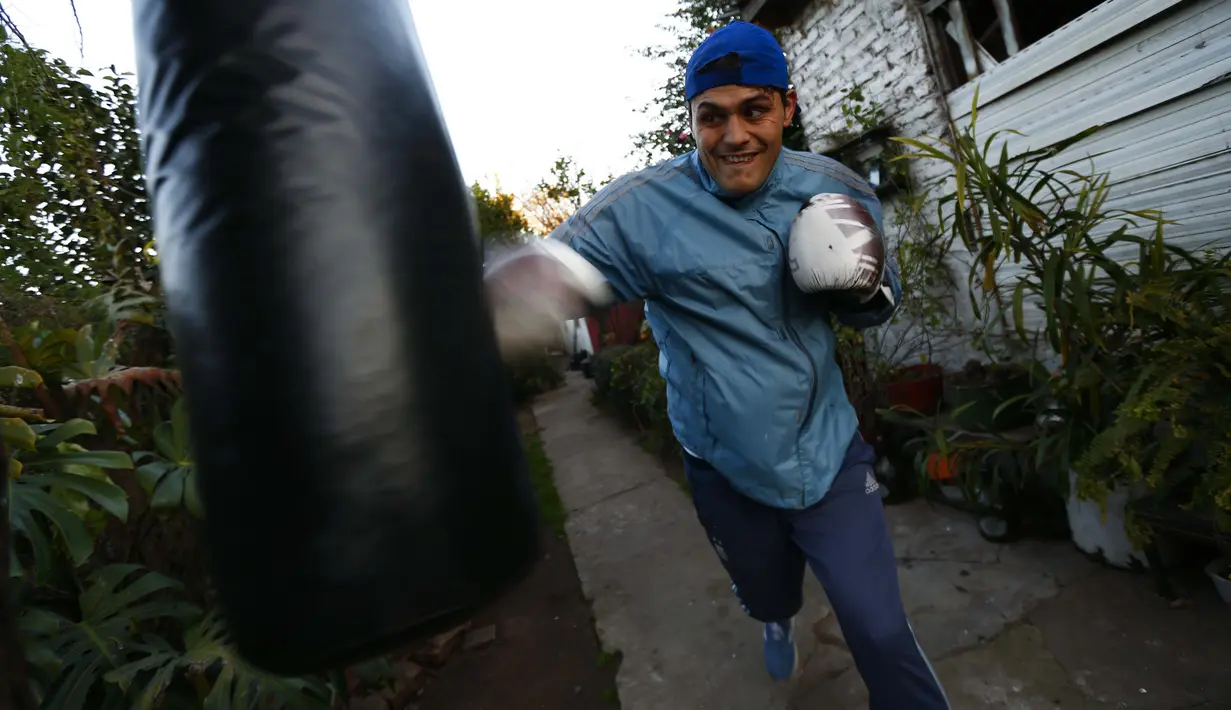 Yamil Peralta melakukan latihan di rumahnya di Jose C. Paz di pinggiran Buenos Aires, Argentina, 29 Juli 2020. Di tengah lockdown, petinju profesional ini membuat alat olahraga darurat di rumahnya untuk berlatih dengan harapan lolos kualifikasi untuk Olimpiade Tokyo 2021. (AP Photo/Marcos Brindicci)