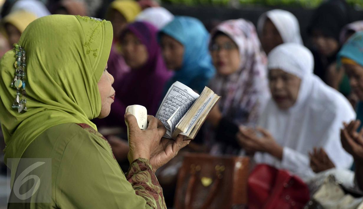 Seorang wanita tampak memimpin doa di depan gedung KPK, Jakarta, Rabu (17/6/2015). Mereka mendoakan Mantan Menteri Agama Suryadharma Ali agar mendapatkan penangguhan penahanan. (Liputan6.com/Helmi Afandi)