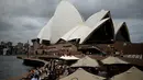 Orang-orang mengunjungi Opera House di Sydney, Australia pada Rabu (30/12/2020). Masyarakat diminta untuk tetap di rumah saja pada malam pergantian tahun menyusul ditemukannya kasus penularan Covid-19 baru di Sydney. (Saeed KHAN / AFP)