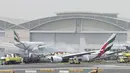 Petugas pemadam kebakaran menyemprotkan air ke pesawat Emirates Airline yang hangus terbakar di Bandara Internasional Dubai, UEA, Rabu (3/8).Kecelakaan ini saat pesawat mencoba mendarat. (Reuters)