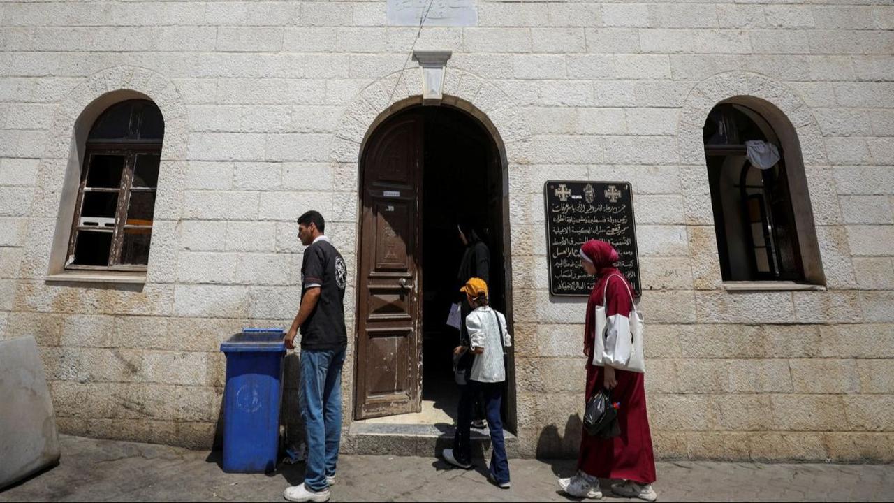 Warga Palestina berdiri di luar Gereja Baptis yang rusak akibat serangan militer Israel dan diubah menjadi klinik&nbsp;di Kota Gaza, Jalur Gaza, pada 1 Juli 2024. Setelah agresi militer Israel menghancurkan sistem kesehatan di Jalur Gaza, pendeta Gereja B