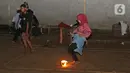 Seorang wanita saat bermain bola api di Kawasan Rempoa, Tangerang Selatan, Rabu (19/08/2020). Bermain Bola api tersebut dilakukan dalam rangka menyambut peringatan tahun baru Islam 1 Muharram 1442 H. (Liputan6.com/Herman Zakharia)