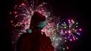 Seorang pria mengenakan kostum santa melihat kembang api selama parade Natal di Panama City (16/12). Warga Panama tengah mempersiapkan diri menyambut datangnya Natal 2018 yang jatuh pada tanggal 25 Desember. (AFP Photo/Luis Acosta)