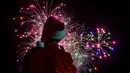 Seorang pria mengenakan kostum santa melihat kembang api selama parade Natal di Panama City (16/12). Warga Panama tengah mempersiapkan diri menyambut datangnya Natal 2018 yang jatuh pada tanggal 25 Desember. (AFP Photo/Luis Acosta)