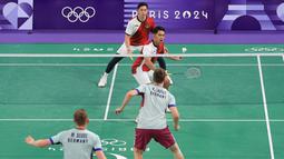 Pebulu tangkis ganda putra Indonesia, Fajar Alfian/Rian Ardianto berfoto berusaha mengembalikan kok ke arah pasangan Jerman, Mark Lamsfuss/Marvin Seidel pada Grup C cabang olahraga bulu tangkis Olimpiade Paris 2024 di Porte de la Chapelle Arena, Paris, Pancis, Sabtu (27/07/2024). (Dok. NOC Indonesia/Naif Muhammad Al’as)