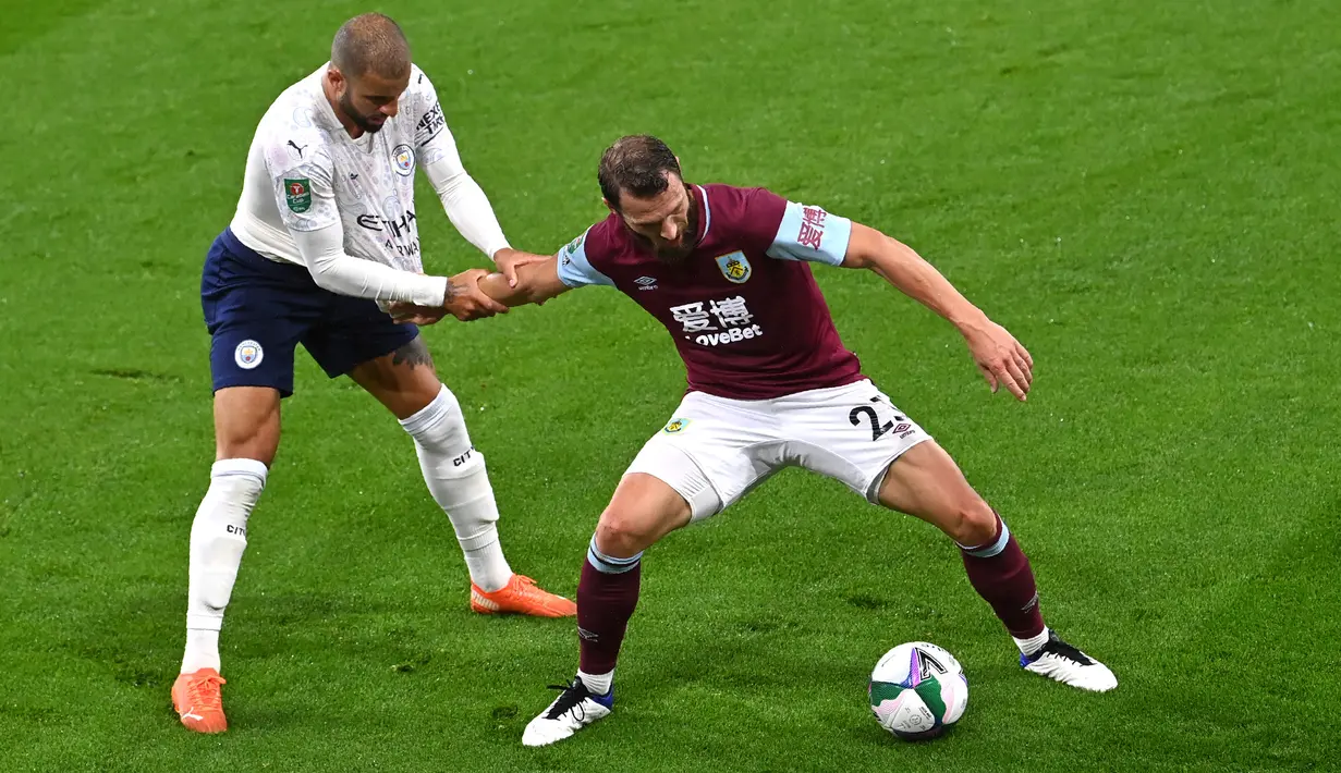Bek Manchester City, Kyle Walker berebut bola dengan pemain  Burnley, Erik Pieters pada laga babak keempat Piala Liga Inggris di Turf Moor, Kamis (1/10/2020) dini hari WIB. Raheem Sterling mencetak dua gol saat Manchester City menang 3-0 atas Burnley. (Paul Ellis/Pool via AP)