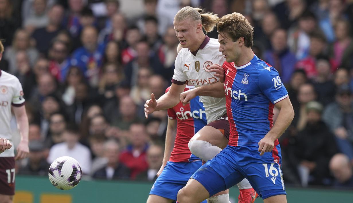 Striker Manchester City, Erling Haaland (kiri) berebut bola dengan bek Crystal Palace, Joachim Andersen pada laga pekan ke-32 Premier League 2023/2024 di Selhurst Park stadium, London, Sabtu (6/4/2024). (AP Photo/Frank Augstein)