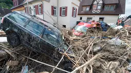 Mobil yang rusak disertai tumpukan ranting pohon yang terbawa oleh aliran arus banjir yang melanda wilayah Braunsbach, Jerman selatan (30/5). Empat orang tewas dan beberapa lainnya luka-luka dalam musibah ini. (Marijan Murat / dpa / AFP)