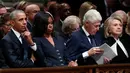Mantan Presiden AS, Barack Obama dan Michelle Obama duduk bersebelahan dengan mantan presiden Bill Clinton dan Hillary Clinton saat prosesi pemakaman kenegaraan George HW Bush di Katedral Nasional Washington, Rabu (5/12). (Alex Brandon/POOL/AFP)