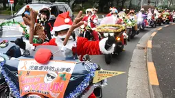 Sejumlah pengendara motor gede mengenakan kostum Santa Claus dan rusa di kota Tokyo, Jepang, (23/12). Sekitar 500 pengendara Harley mengikuti touring ini. (AFP PHOTO/Toru Yamanaka)