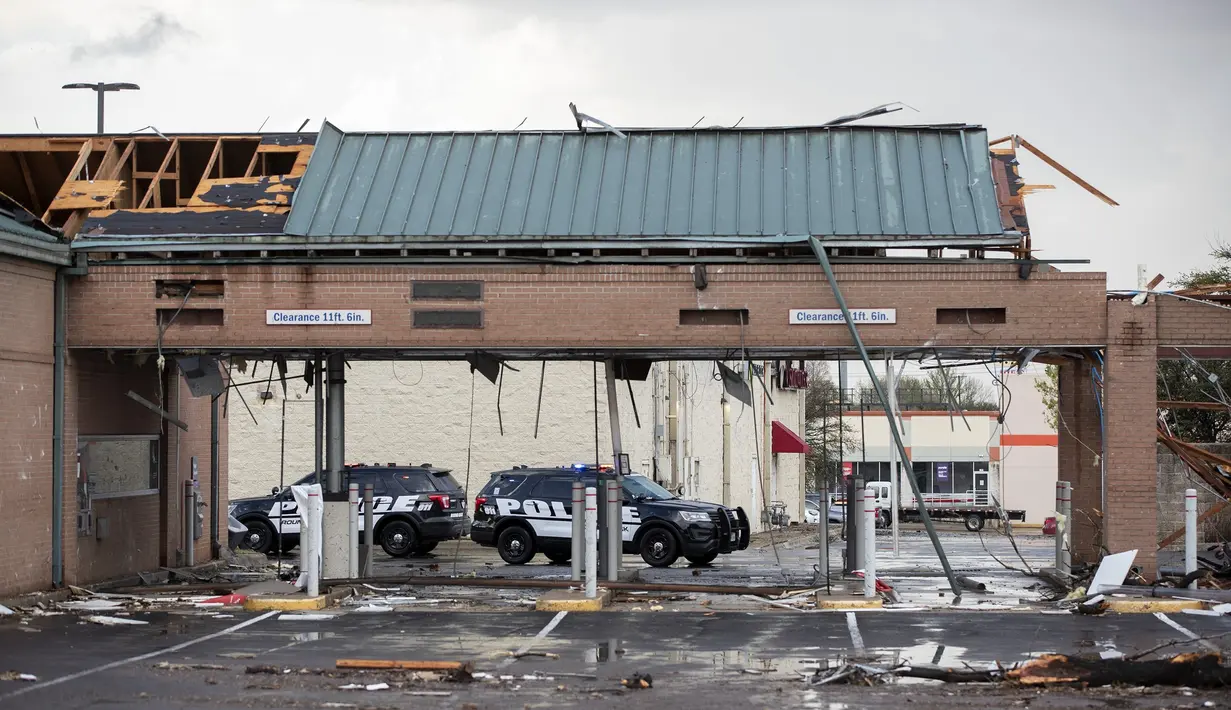 Mobil polisi rusak akibat diterjang badai tornado di luar bank, dekat I-35 dan SH 45 di Round Rock, Texas, Senin (21/3/2022). (Jay Janner/Austin American-Statesman via AP)