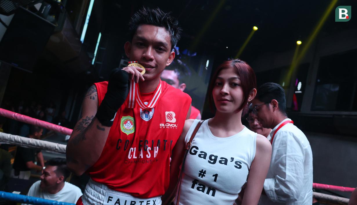 Gaga Muhammad berfoto dengan kekasihnya usai menang melawan Raja 'Big Heca' pada ajang bertajuk University Boxing League (UBL) yang berlangsung di Embassy Lounge Jakarta, Senayan, Jumat (20/9/2024) malam WIB. (Bola.com/Abdul Aziz)
