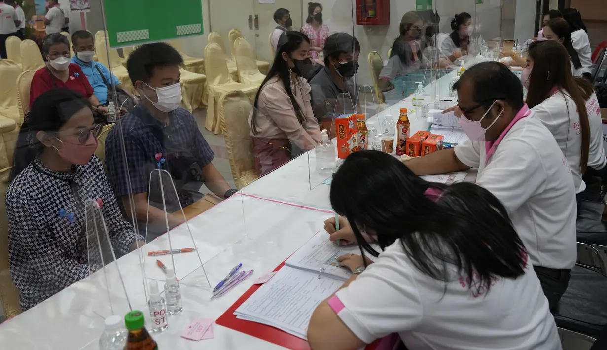 Puluhan pasangan yang mengenakan masker untuk melindungi diri dari penyebaran virus corona menunggu untuk menandatangani surat nikah mereka pada Hari Valentine di distrik Bang-Rak, yang diterjemahkan sebagai "Distrik Cinta", di Bangkok, Thailand, Senin (14/2/2022). (AP Photo/Sakchai Lalit)