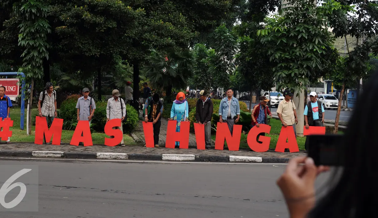 Warga mengabadikan aksi #masihingat yang dilakukan sejumlah keluarga korban kekerasan di Taman Gunung Agung Jakarta, Rabu (29/6). Aksi ini mengingatkan masih banyak kasus pelanggaran HAM yang belum tuntas. (Liputan6.com/Helmi Fithriansyah)