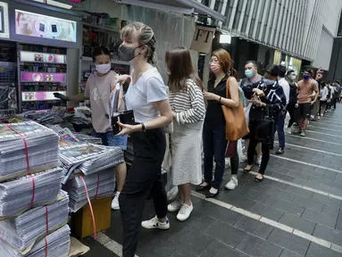 Orang-orang mengantre untuk edisi terakhir Apple Daily di stan surat kabar di sebuah jalan pusat kota di Hong Kong, Kamis (24/6/2021). Ratusan orang mengantre pada Kamis dini hari untuk membeli edisi cetak terakhir surat kabar pro-demokrasi Hong Kong, Apple Daily. ( AP Photo/Vincent Yu)