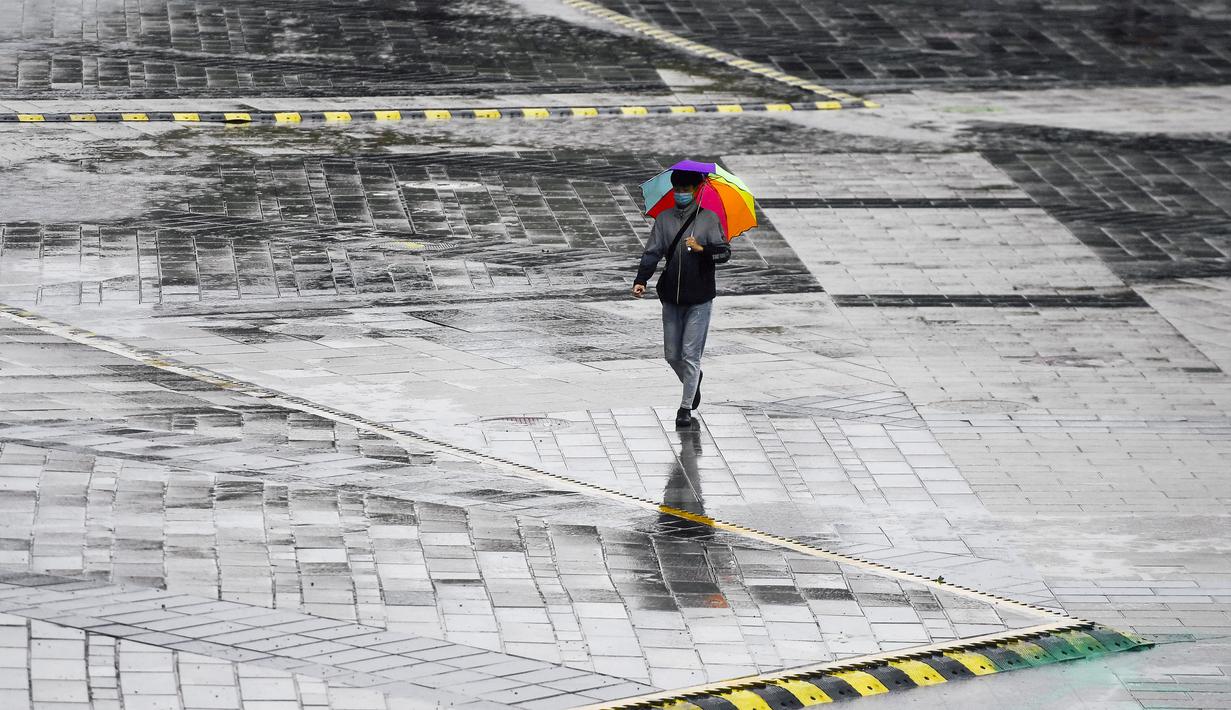 Seorang pria berjalan di bawah guyuran hujan yang dipicu Topan Haishen di Changchun, Provinsi Jilin, China, 8 September 2020. Hujan deras melanda sebagian besar wilayah Kota Changchun sejak Senin malam waktu setempat hingga Selasa yang dipicu Topan Haishen, topan ke-10 tahun ini. (Xinhua/Xu Chang)