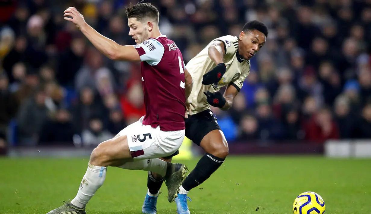 Penyerang Manchester United, Anthony Martial, berebut bola dengan pemain Burnley, James Tarkowski, pada laga Premier League di Stadion Turf Moor, Sabtu (28/12). Burnley takluk 0-2 dari Manchester United. (AP/Martin Rickett)