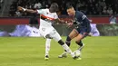 Penyerang PSG, Kylian Mbappe berusaha melewati pemain Lorient, Houboulang Mendes pada pertandingan lanjutan Liga 1 Prancis di stadion Parc des Princes di Paris, Senin (4/4/2022). Hasil ini membuat PSG mengumpulkan 68 poin dari 30 pertandingan. (AP Photo/Michel Euler)