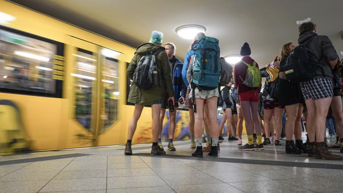 Penumpang tanpa menggunakan celama menunggu kereta di subway selama acara tahunan No Pants Subway Ride di Berlin pada Minggu (12/1/2020). New York menjadi kota pertama yang menghajat acara naik kereta tanpa celana ini sejak tahun 2002. (Jörg Carstensen / dpa / AFP)