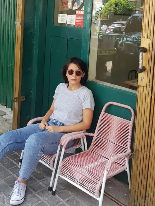 Duduk di depan sebuah kedai, Hannah tampil sangat santai. Menggunakan baju kaus polos berwarna abu-abu dan jeans, sepatu putihnya membuat penampilannya senada dari atas hingga bawah. Kacamata hitam menegaskan penampilan santainya. (Liputan6.com/IG/@hannahalrashid)