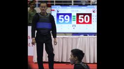 Kejadian bermula ketika pesilat Indonesia, Khoirudin Mustakim (kiri) bertarung dengan atlet Malaysia, Muhammad Khairi Adib dalam perebutan medali emas pada kelas B putra 50-55 kg. Mustakim yang sudah unggul dianggap melakukan pelanggaran berat terhadap pesilat Malaysia. (Bola.com/Ikhwan Yanuar)