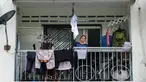 Ibu tunggal Tilda Kalaivani melambaikan kemeja yang digunakan sebagai bendera putih di apartemen sewaannya di Kuala Lumpur pada 6 Juli 2021. Akibat lockdown nasional, banyak keluarga berpenghasilan rendah yang terdampak oleh pandemi COVID-19 semakin kesulitan dalam menjalani hidup. (Mohd RASFAN/AFP)