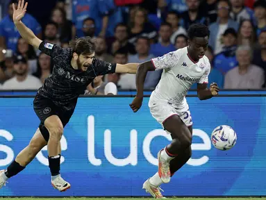 Pemain Napoli Khvicha Kvaratskhelia (kiri) berebut bola dengan pemain Fiorentina Oliver Christensen pada pertandingan sepak bola Serie A Liga Italia di Stadion Diego Armando Maradona, Naples, Italia, Minggu (8/10/2023). (Alessandro Garofalo/LaPresse via AP)