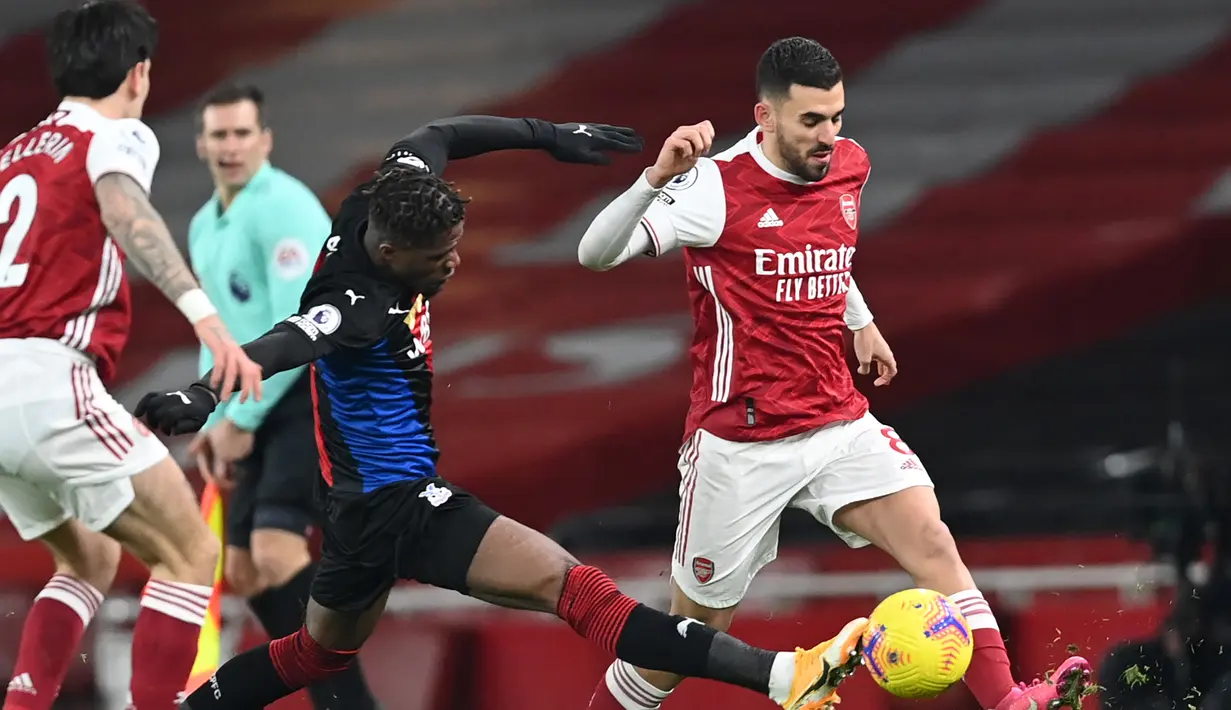 Gelandang Arsenal, Dani Ceballos (kanan) berebut bola dengan striker Crystal Palace, Wilfried Zaha dalam laga lanjutan Liga Inggris 2020/21 di Emirates Stadium, Kamis (14/1/2021). Arsenal bermain imbang 0-0 dengan Crystal Palace. (AFP/Neil Hall/Pool)