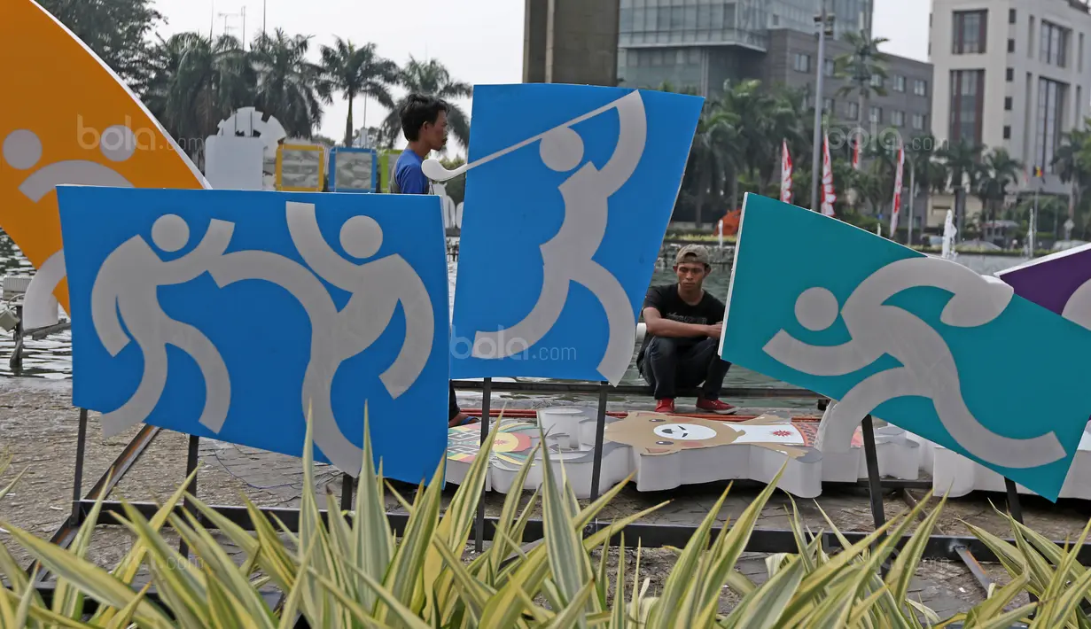 Pekerja menanti giliran memasang logo Asian Games 2018 di Bundaran HI, Jakarta, (17/8/2017), Asian Games mengambil tema Energy Of Asia dan akan dibuka oleh Presiden Republik Indonesia Joko Widodo. (Bola.com/Nicklas Hanoatubun)