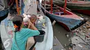 Seorang ibu memandikan anaknya di atas kapal pasca penggusuran permukiman Pasar Ikan, Jakarta, Selasa (13/4). Warga Pasar Ikan mengaku belum mendapat rumah susun sewa yang telah dijanjikan oleh Pemprov DKI Jakarta. (Liputan6.com/Faizal Fanani)