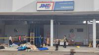 Petugas kepolisian memberikan police line di gudang JNE Cimanggis yang terbakar. (Liputan6.com/Dicky Agung Prihanto)