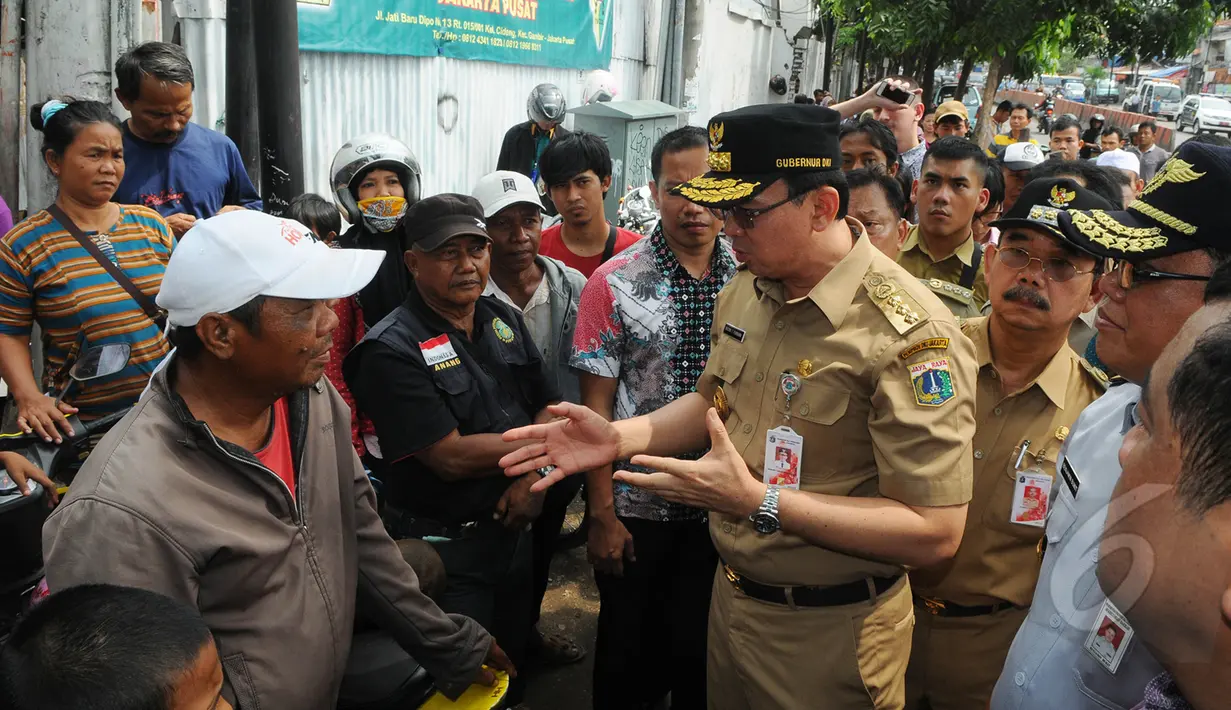 Gubernur DKI Jakarta Basuki T Purnama berbincang dengan warga saat menuju pasar Tanah Abang, Jakarta, Rabu (15/4). Ahok berjalan kaki dari Stasiun Tanah Abang menuju Pasar Blok G untuk mengecek kondisi trotoar jalan. (Liputan6.com/Herman Zakharia)