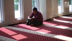 Seorang umat muslim membaca Alquran di Masjid Al-Madinah, Parung, Bogor, Selasa (7/5/2019). Sejumlah umat muslim meningkatkan ibadah pada bulan suci Ramadhan 1440 H dengan membaca Alquran (tadarus), shalat berjamaah, berdoa dan dzikir di masjid. (merdeka.com/Arie Basuki)