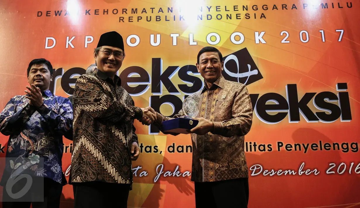 Ketua DKPP Jimly Asshiddiqie memberikan simbolis penghargaan kepada Menko Polhukam Wiranto (kanan) seusai pembukaan kegiatan Outlok 2017 atau Refleksi Akhir Tahun bertajuk Evaluasi dan Proyeksi di Jakarta, Rabu (14/12). (Liputan6.com/Faizal Fanani)